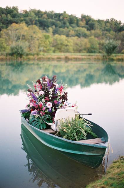 Детали свадебной фотосессии на природе: лодка и цветы